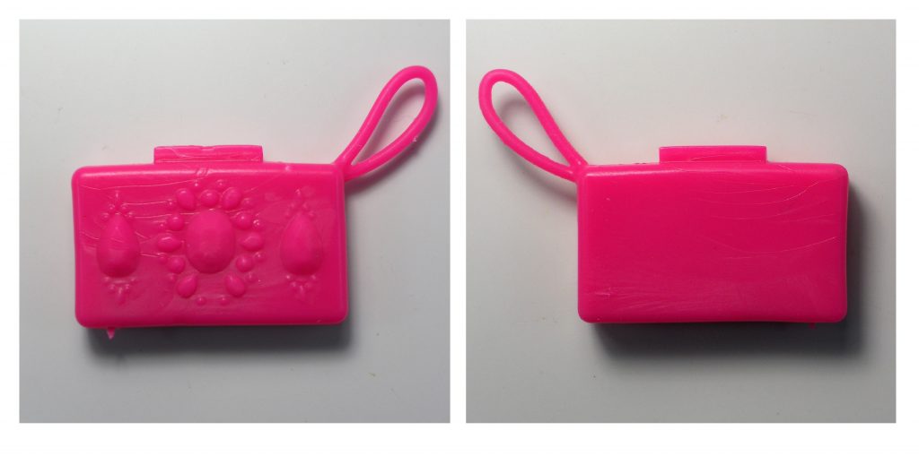 The small hot pink clutch purse has a strap and is patterned on one side